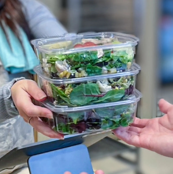Stack of 3 GooDguard conatiners with securely packaged salads.