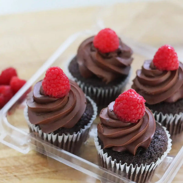 4 chocolate cupcakes with swirls frosting and a raspberry on top.