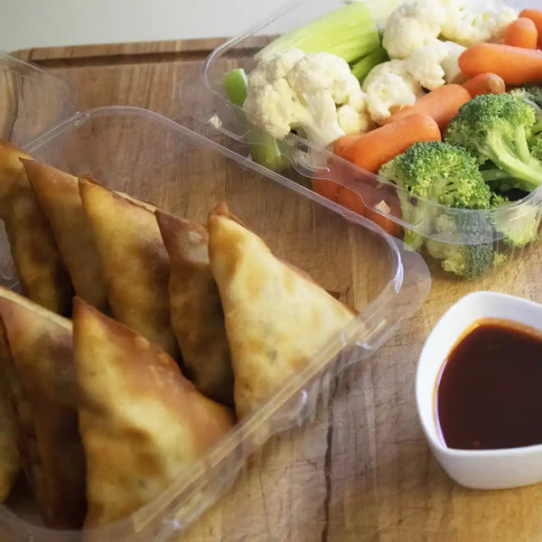 Containers with Samosas and veggies.